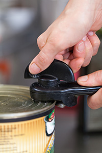 Man Demonstrates how to use a can opener